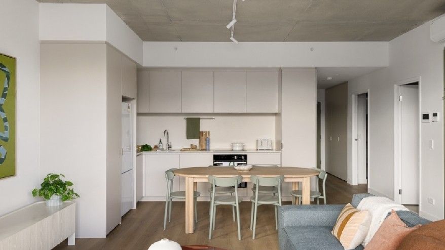 Living room with a blue couch, dining area, and kitchen at Swift Walk.