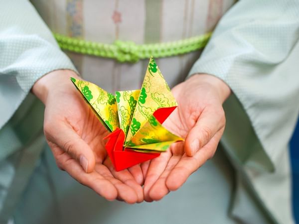 A man with an origami bird folding at Hotel Okura Manila