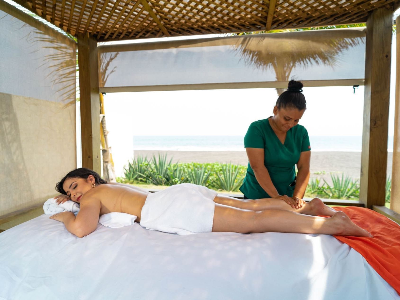 A lady receiving a massage by a masseuse at La Mar Monterrico