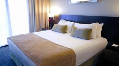 Cama King en habitación con vista al río y balcón en Panoramic Grand