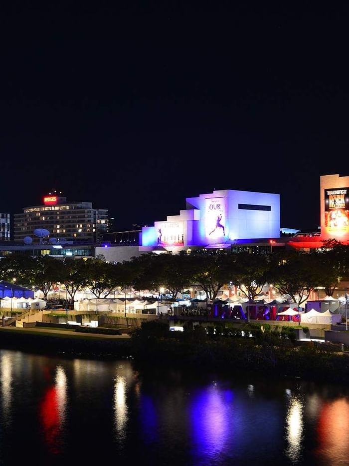 Night view with lit ferris wheel by lake in Le Festival near Sofitel Brisbane Central