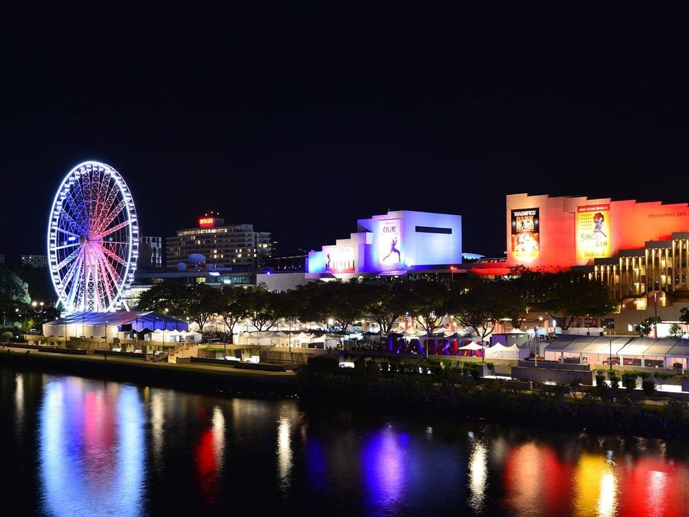 Night view with lit ferris wheel by lake in Le Festival near Sofitel Brisbane Central