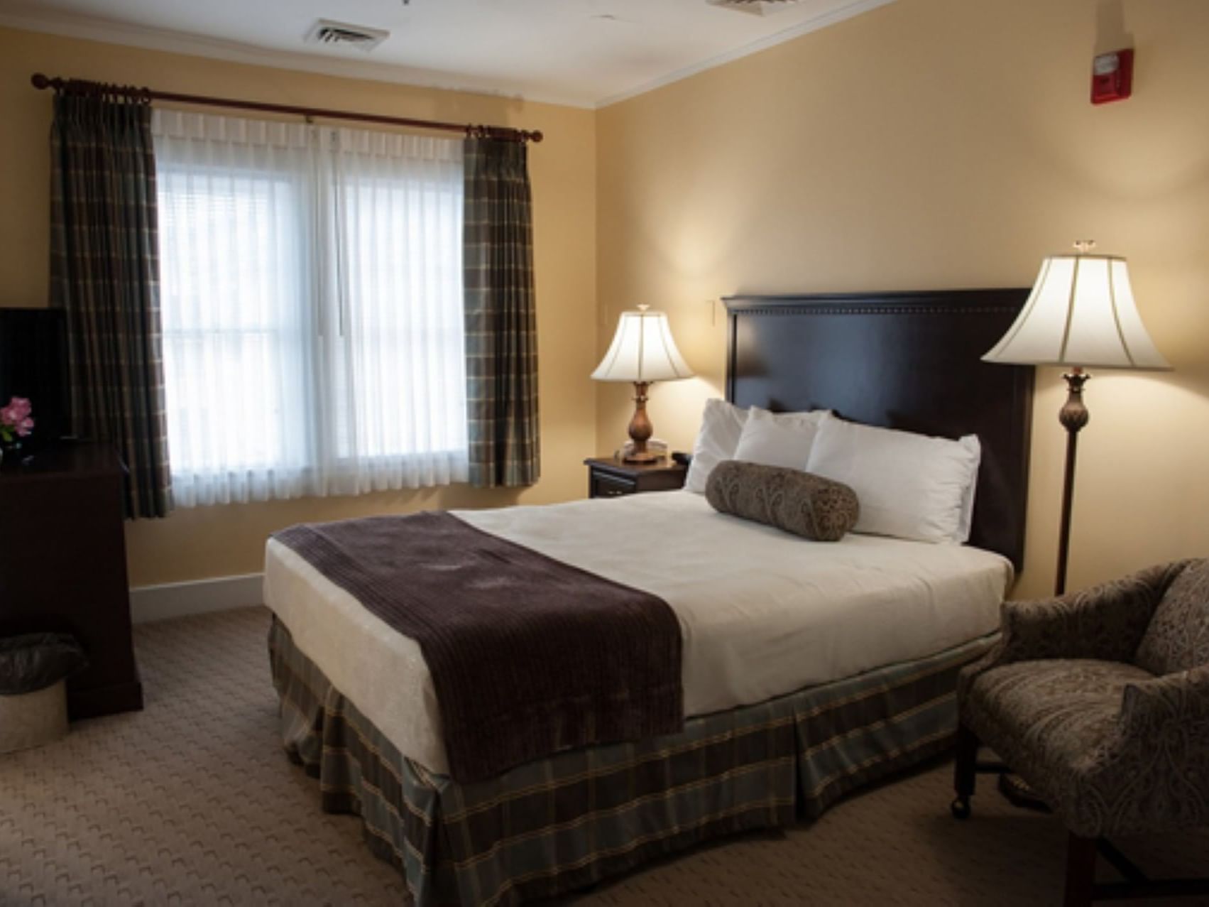 King bed, nightstand, lounge & TV in Select Rooms at The Bethel Inn Resort & Suites