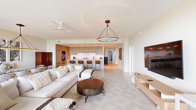 TV lounge with plush seating and kitchenette in S301 at The Residences at Seafire