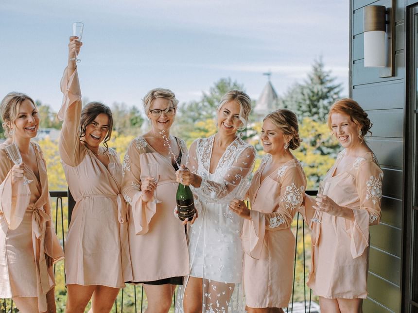 Bridesmaids in blush pink robes holding champagne glasses at The Earl