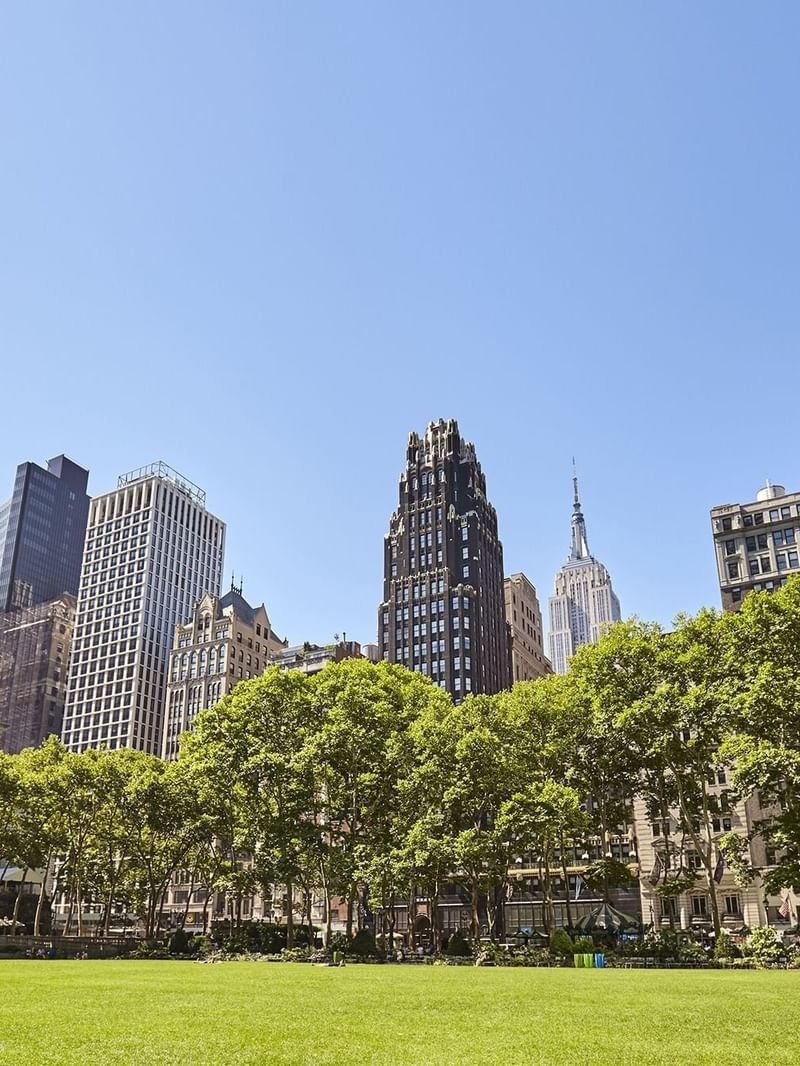Bryant Park surrounded by skyscrapers near Warwick Hotels & Resorts