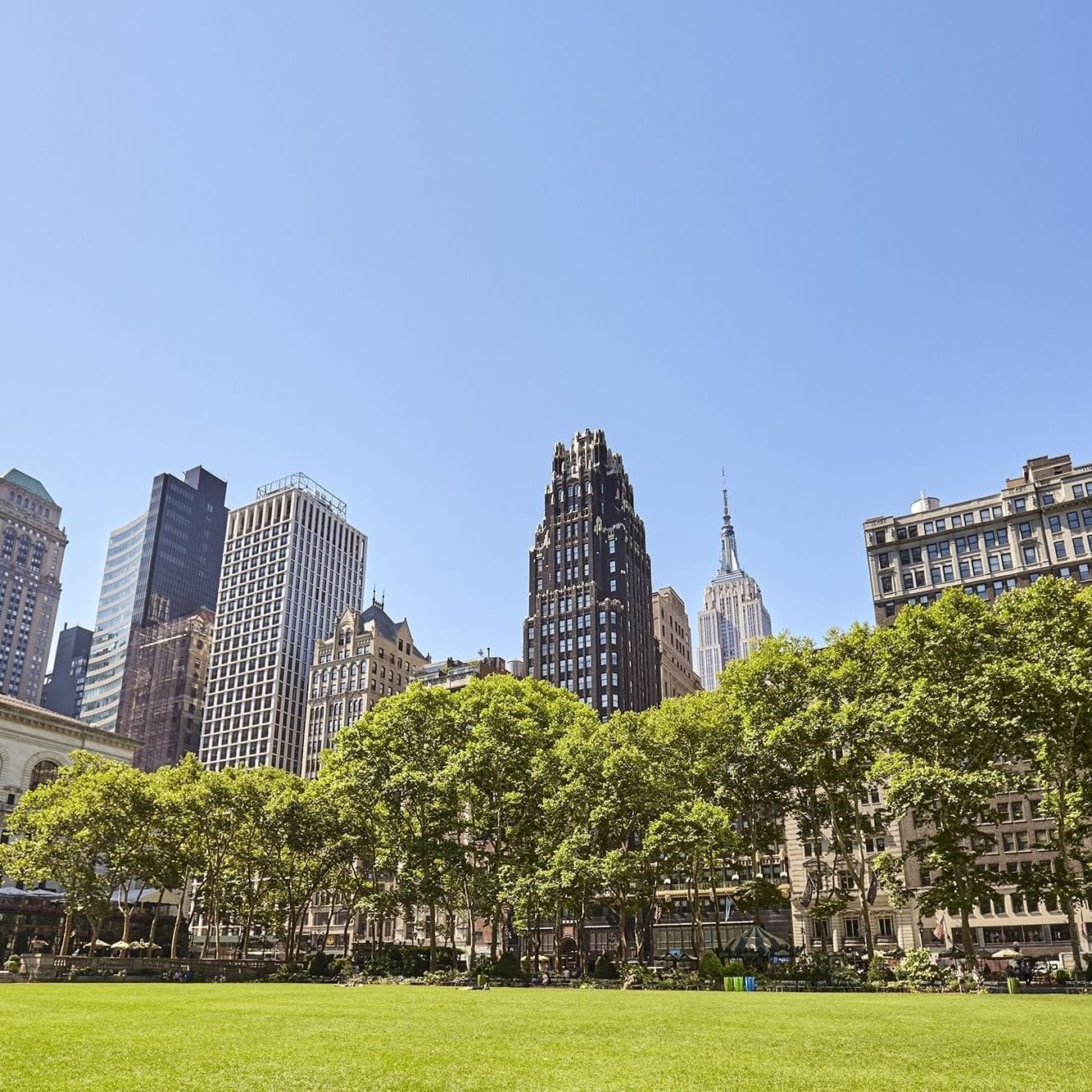 Bryant Park surrounded by skyscrapers near Warwick Hotels & Resorts