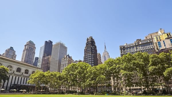 Bryant Park surrounded by skyscrapers near Warwick Hotels & Resorts