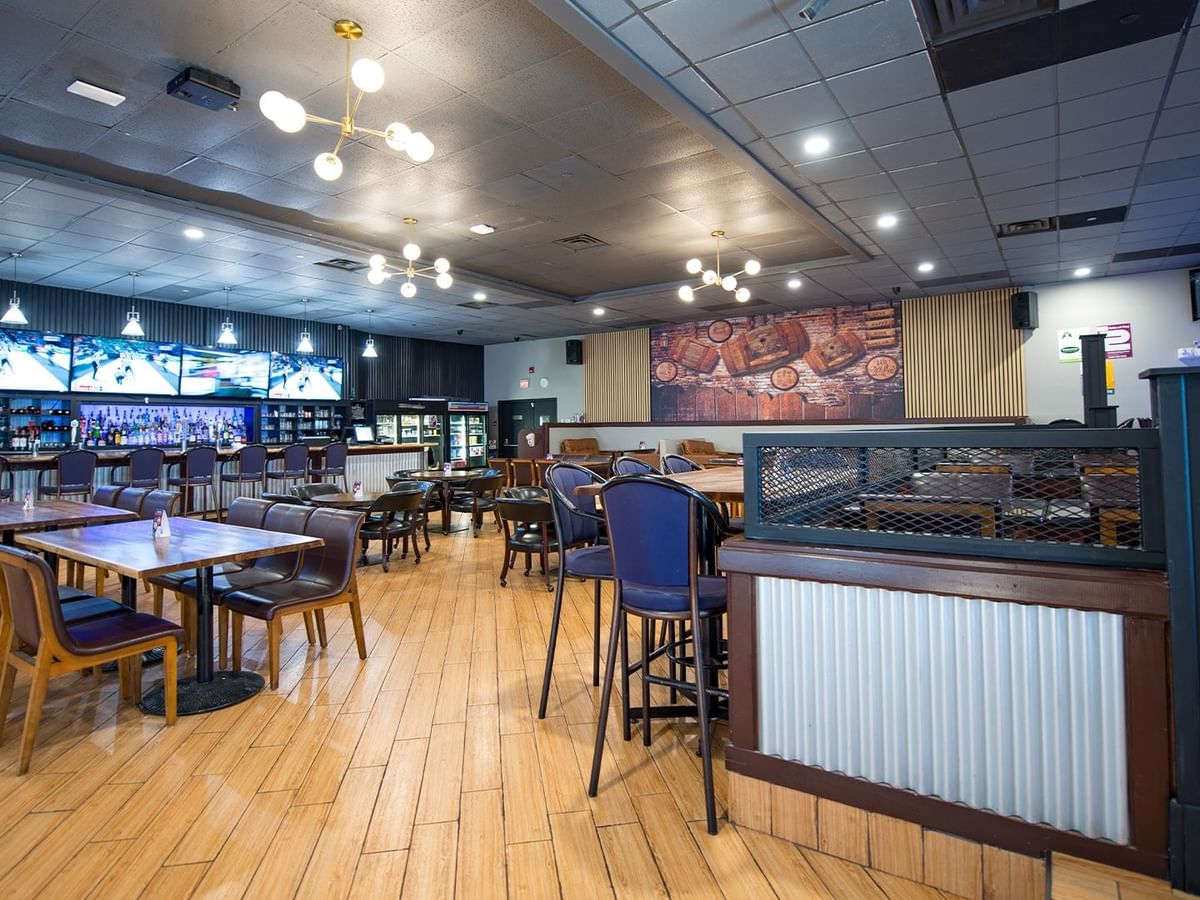 Interior view of The Den Pub with tables, chairs, and a bar.