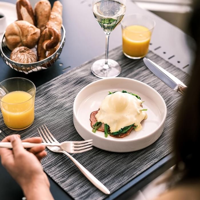 Eggs benedict on a plate with spinach, ham and wine at Falkensteiner Hotel Montafon