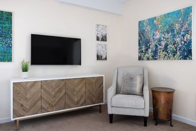 Cozy chair, side cupboard & TV in Queen Premiere at Retro Suites Hotel