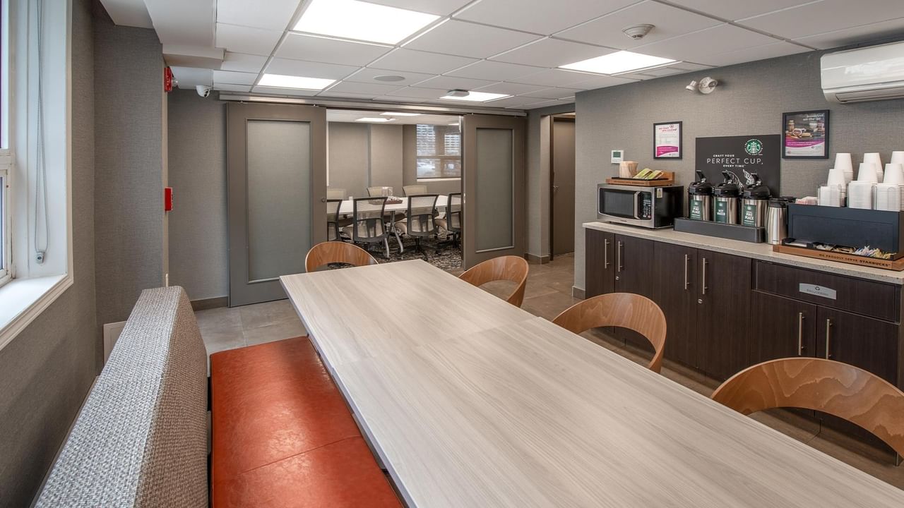 Coffee room with long table outside of the meeting room.