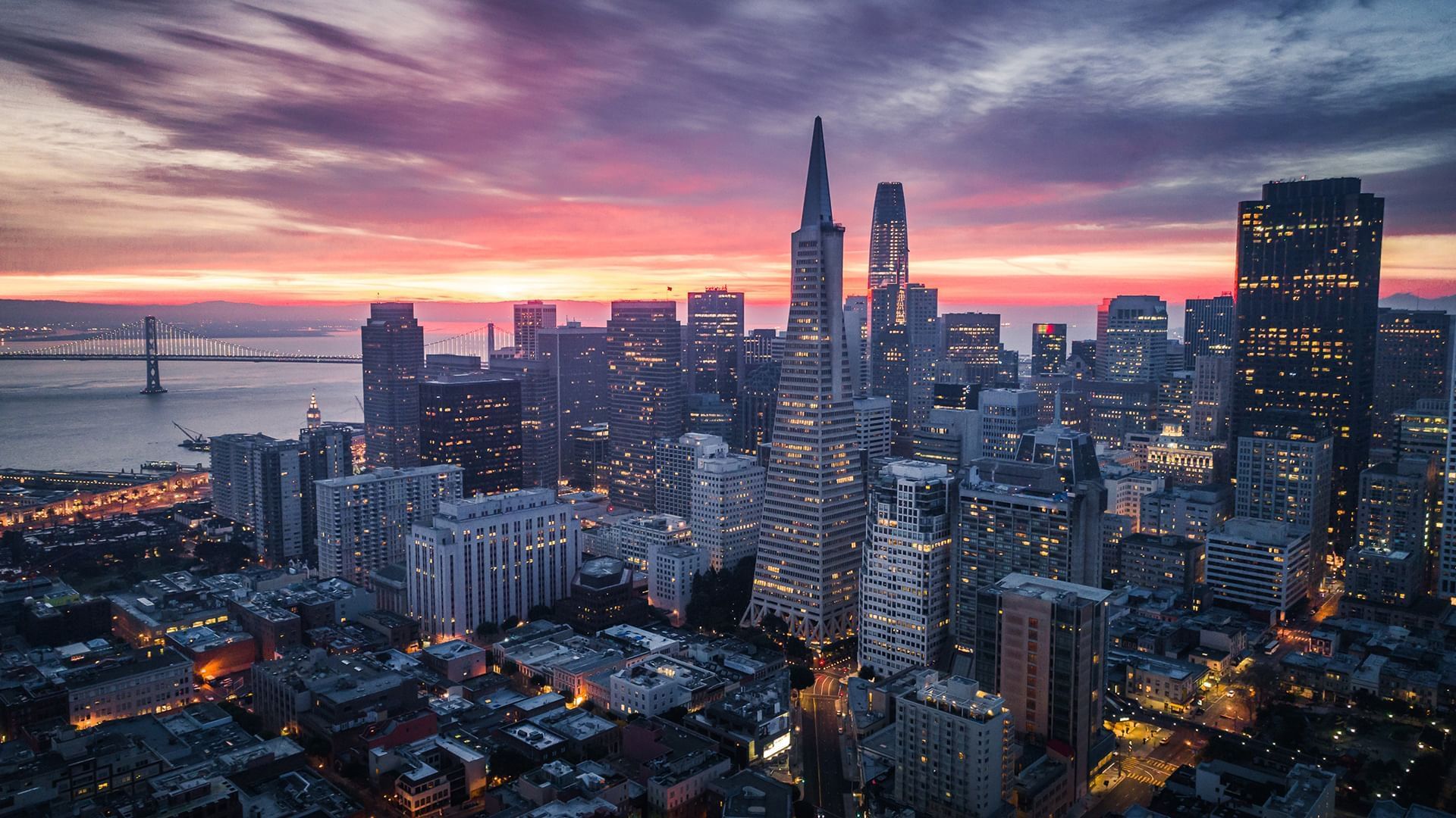 Sunset over San Francisco's skyline near Warwick Hotels and Resorts, featuring skyscrapers and illuminated streets below
