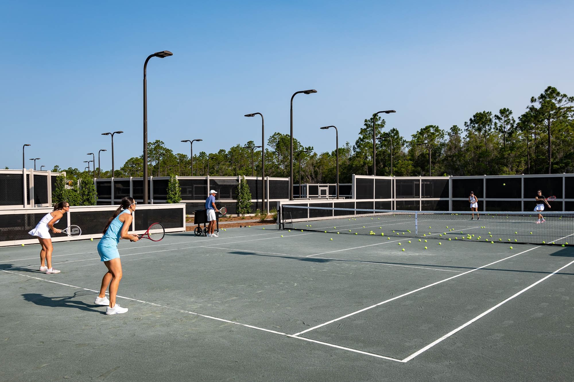 Girls wearing sportswear playing Tennis in a court at Camp Creek Inn