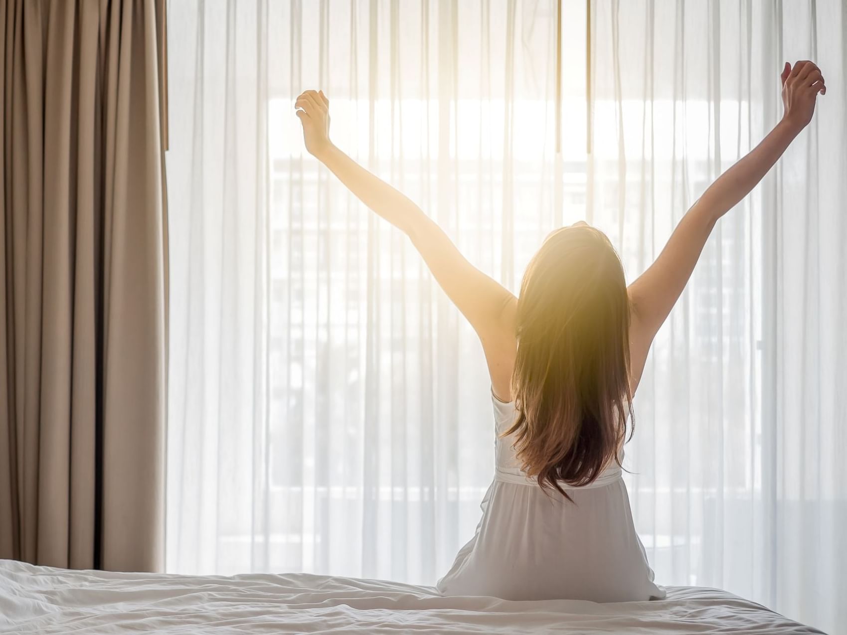 Woman relaxing in a guest room at Hotel Grand Chancellor Brisbane, an ideal choice for Brisbane CBD multi-night hotel deals.