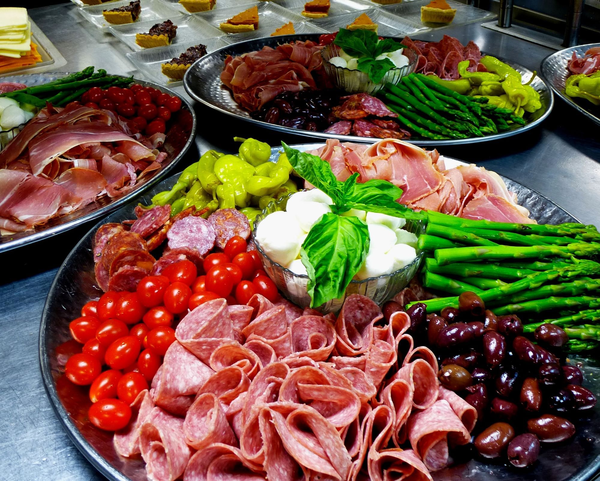A selection of cured meats, vegetables, and cheese on a platter