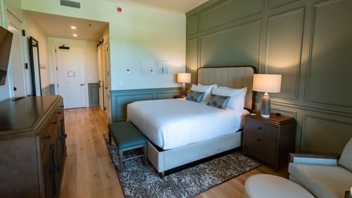 Drawer & TV facing the king bed in Golf View King Room With Balcony at Camp Creek Inn