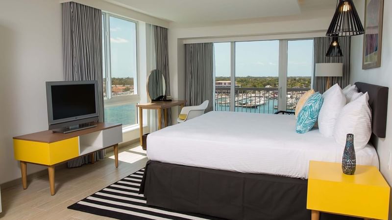 King-size bed, work desk & a TV in One Bedroom Harborfront Suite at Warwick Paradise Island Bahamas