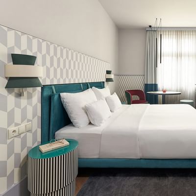 Superior Room s postelí, skříní a TV na Falkensteiner Hotel Prague v Praze.