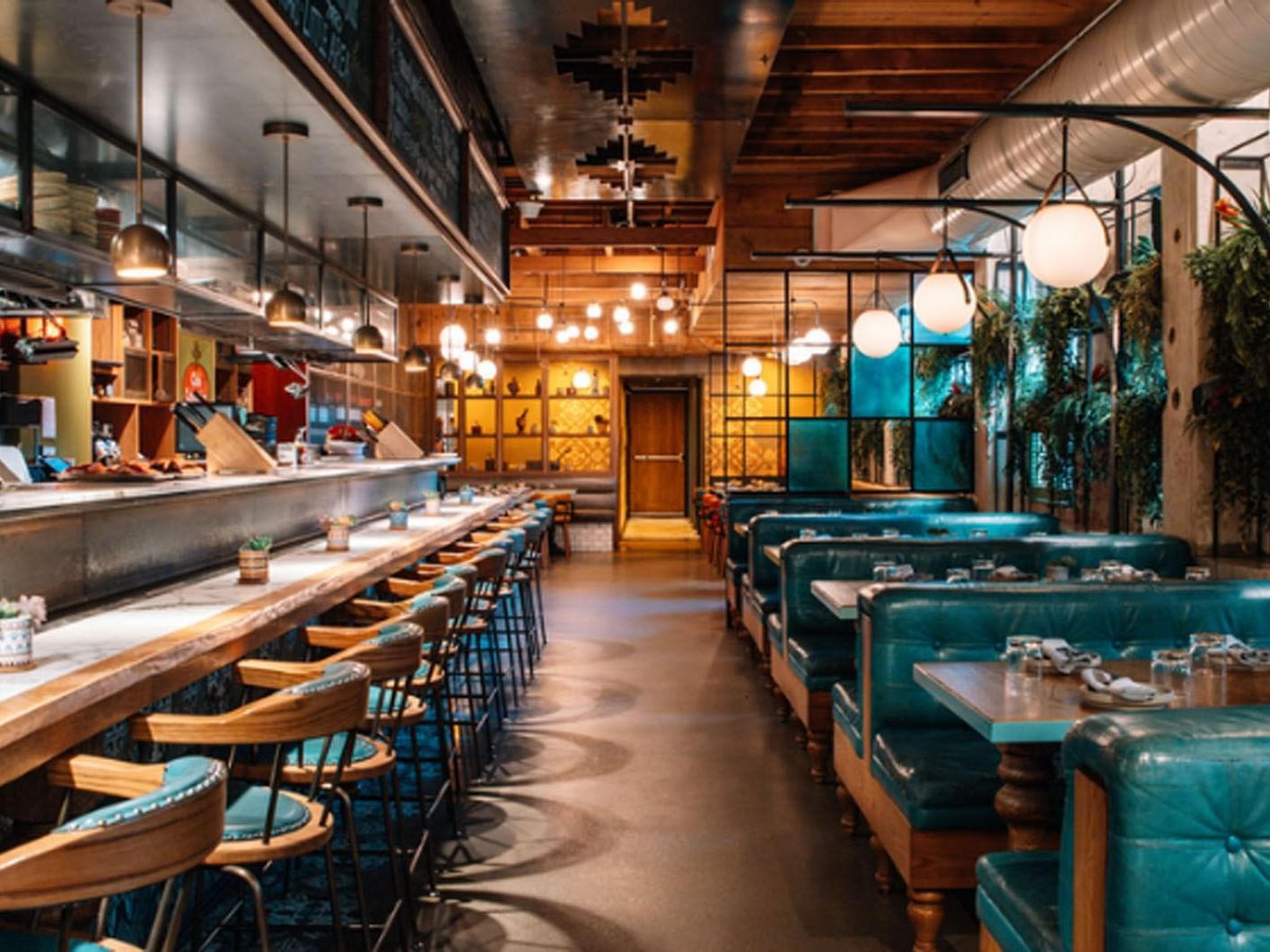 Baro with bar seating and turquoise booths under warm lighting near Hotel X, a downtown Toronto hotel