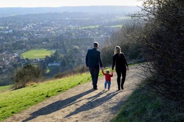 Family exploring the scenic trails of Box Hill in Surrey on a sunny day.