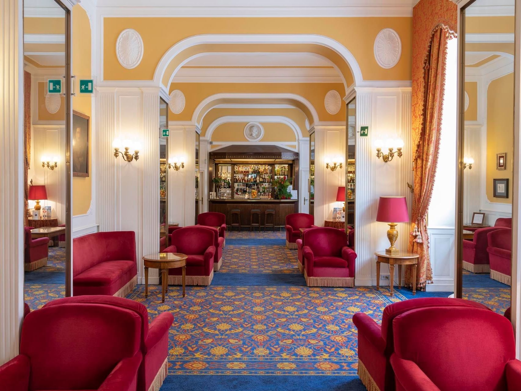 Hotel lobby with red chairs and blue carpet at Bettoja Hotel Massimo D´Azeglio