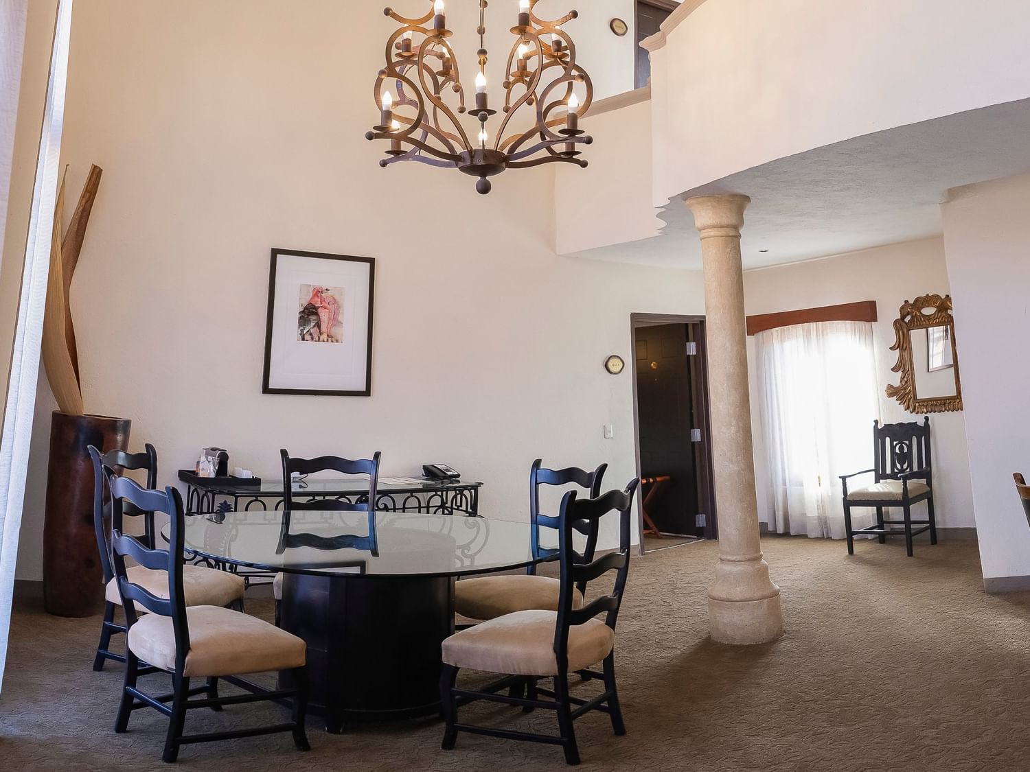 Spacious King Presidential Suite dining area with round table, ornate chandelier, and stone column at Quinta Real Zacatecas