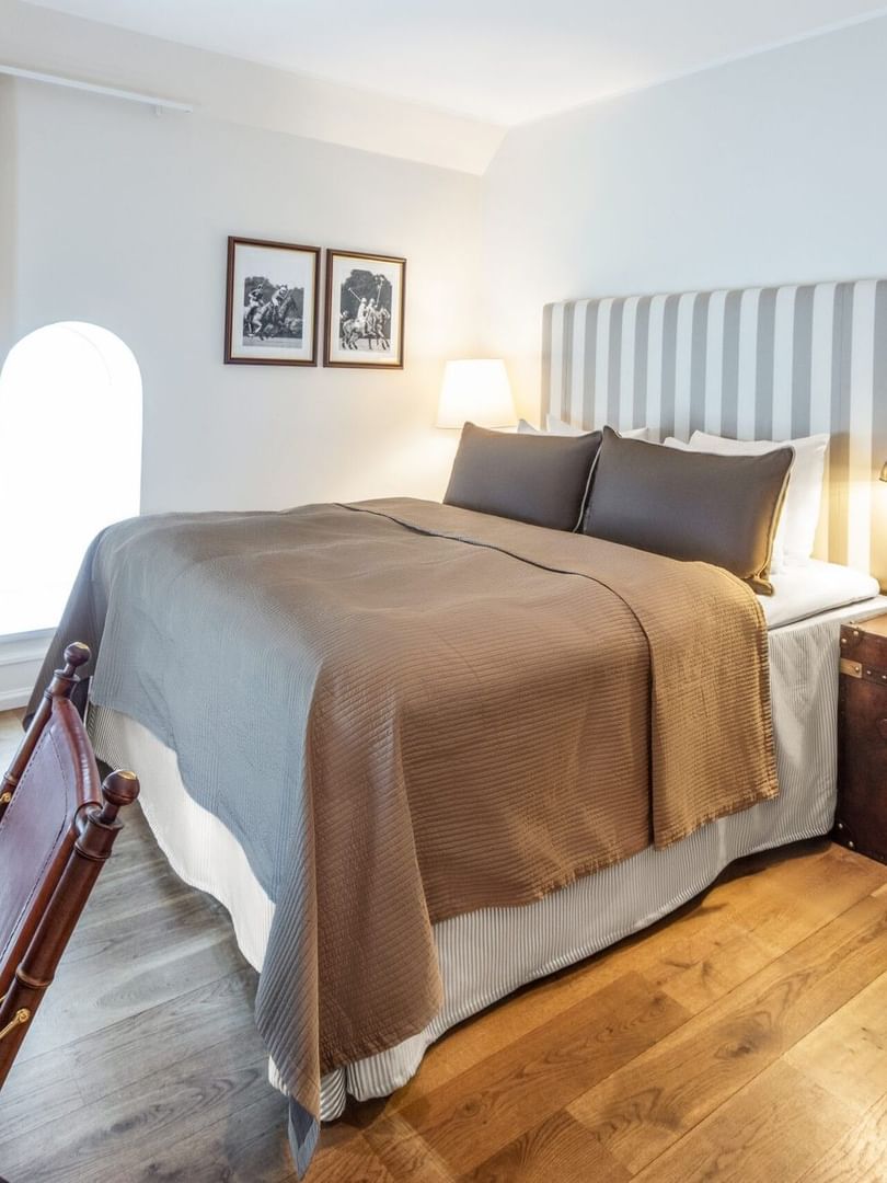 Standard room featuring brown bedspread and beside table lamp with small wall arts at Warwick Denmark