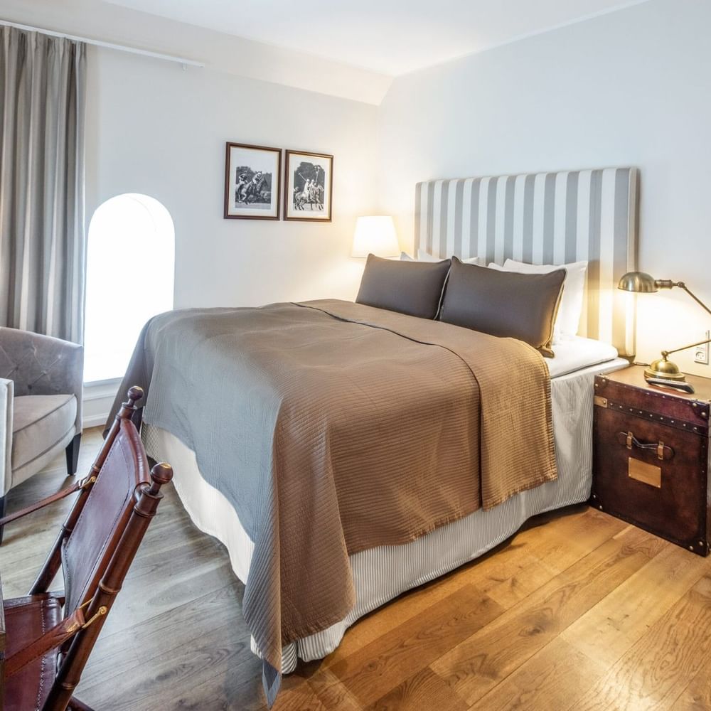 Standard room featuring brown bedspread and beside table lamp with small wall arts at Warwick Denmark
