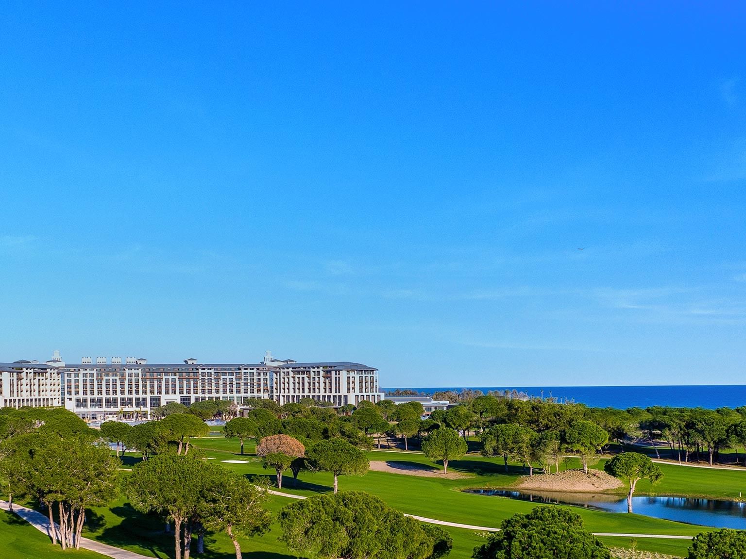Exterior view of Cullinan Belek with a golf course and coastline