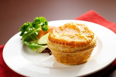 Close-up of Regular Chicken Pie served with a side salad at York Hotel Singapore