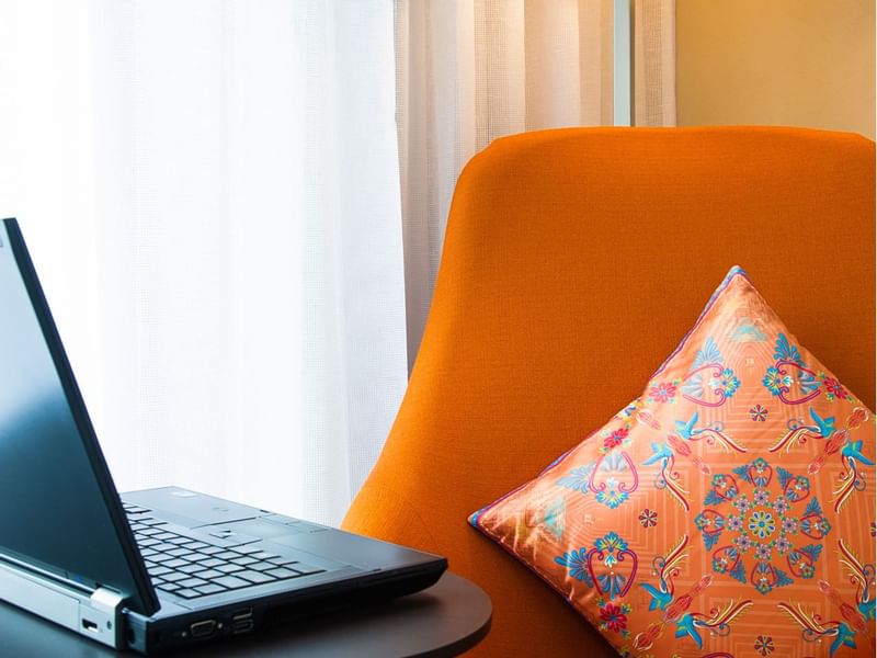 Close up on a laptop and sofa in a room at Fiesta Inn