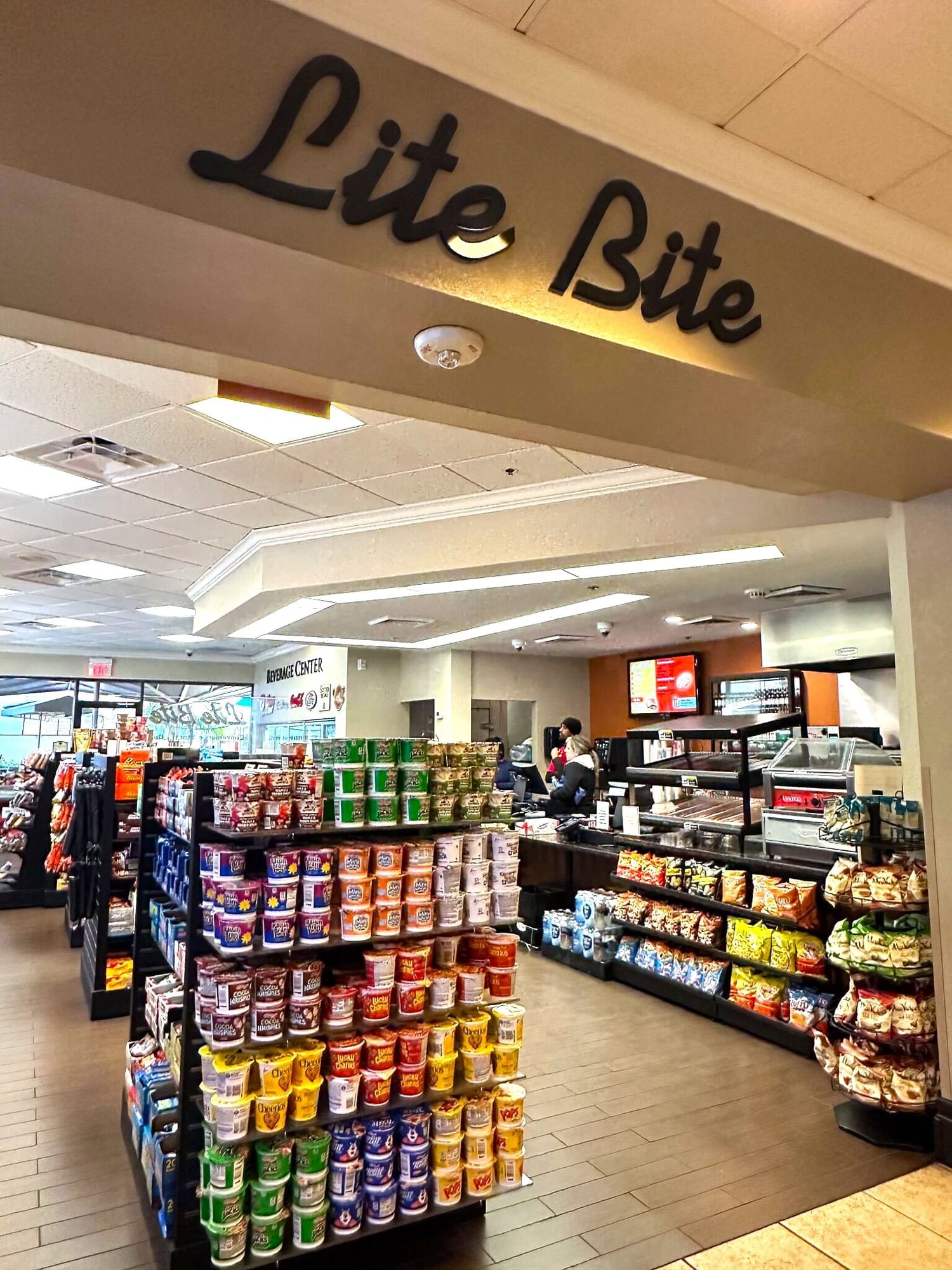 The entrance to a market with shelves of snack food and a sign above that reads Lite Bite. 