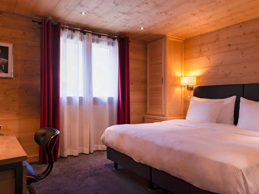 Double bedroom with open windows at Chalet hotel la marmotte