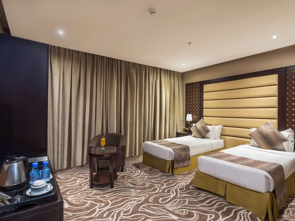 Twin Deluxe with twin beds and carpeted floor at Warwick Al Khobar