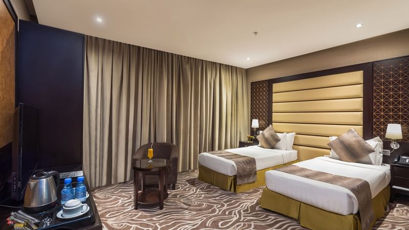 Two beds with seating in Deluxe Twin at Warwick Hotels & Resorts