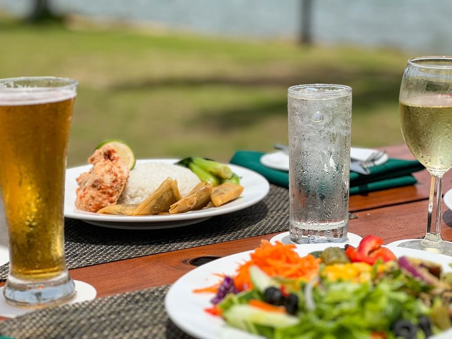Plates with meals and three drinks on table at The Naviti Resort - Fiji.
