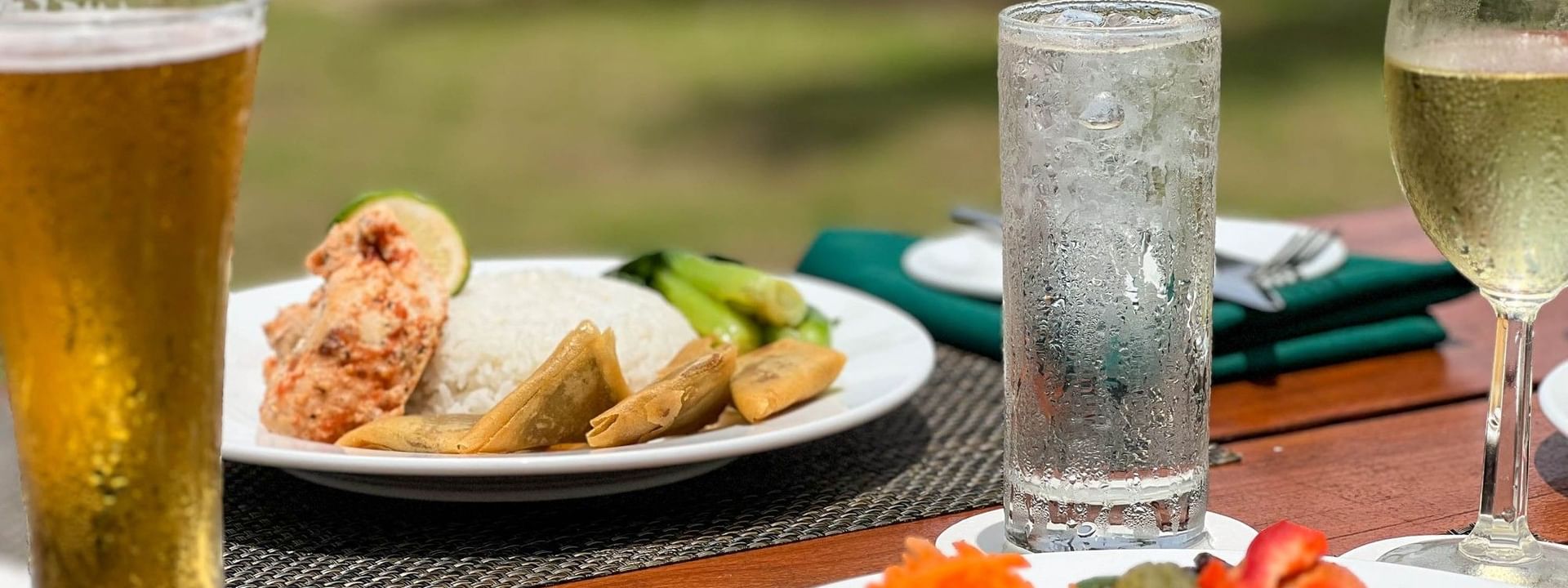 Plates of salad, fish, and rice with drinks at The Naviti Resort Grill in Korolevu