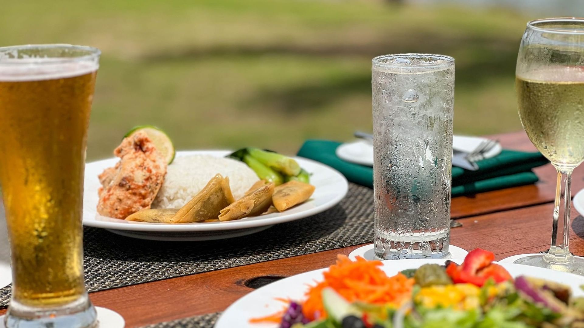 Plates of salad and seafood with a beer and wine at The Naviti Resort in Korolevu
