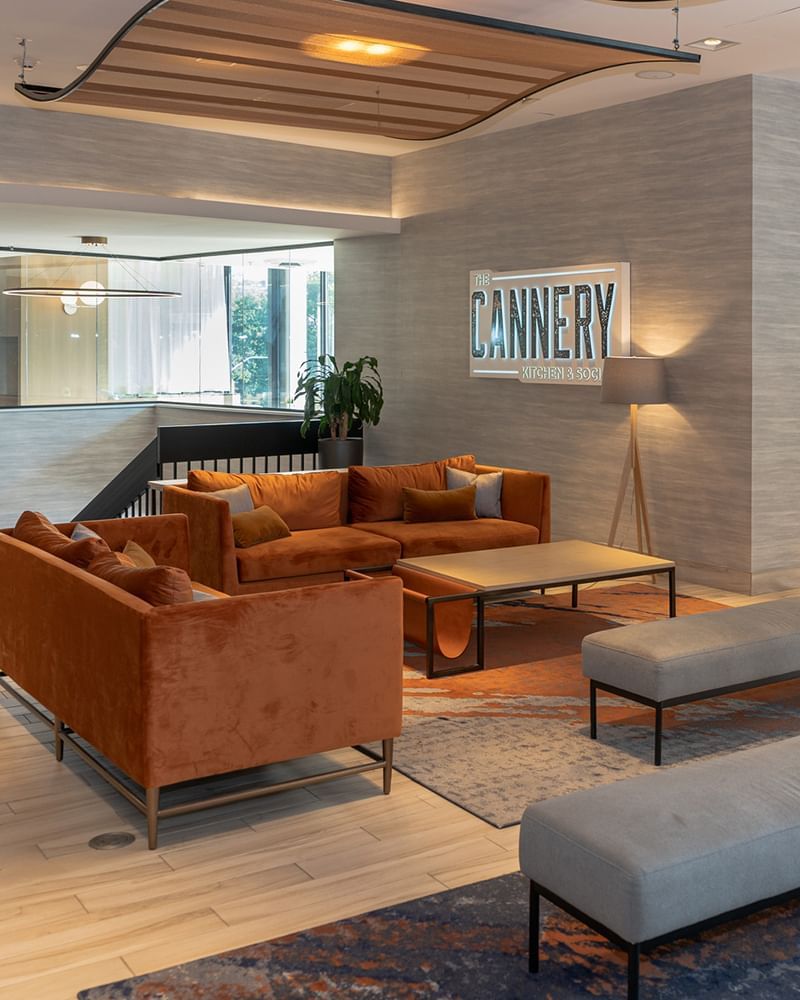 Lounge area with two orange couches, a coffee table, and 