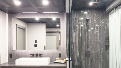 Modern bathroom with sink and hexagonal tile at Carriage House Hotel & Conference Centre