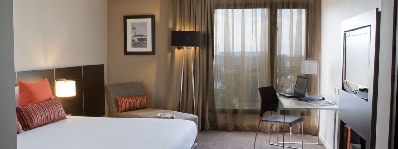 Work desk facing bed and couch by the window in Superior Room at Novotel Sydney International Airport