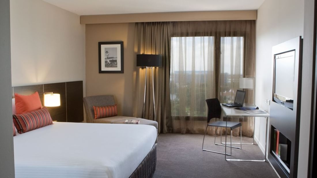 Work desk facing bed and couch by the window in Superior Room at Novotel Sydney International Airport