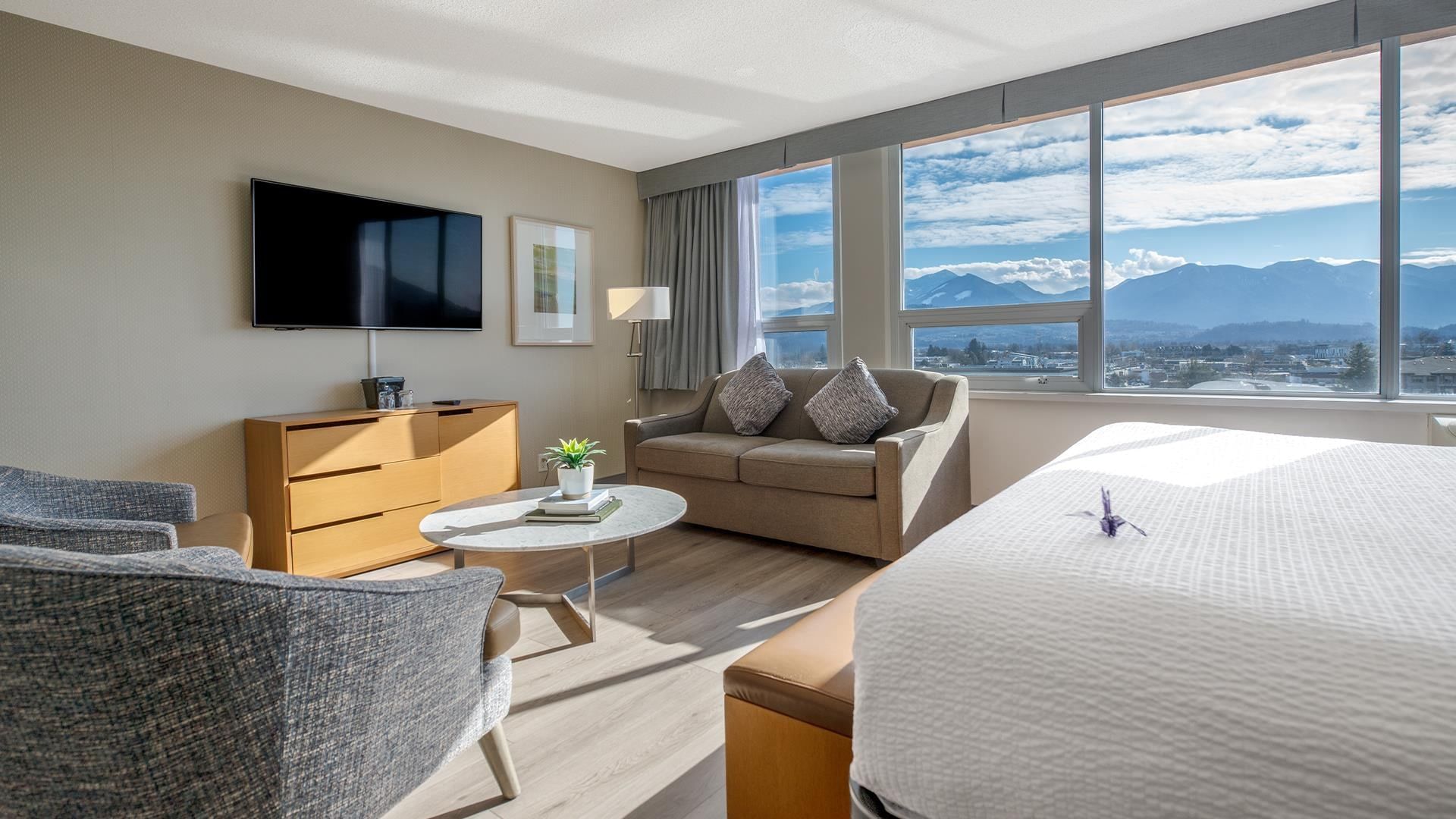 Modern hotel room with lounge area and scenic mountain view