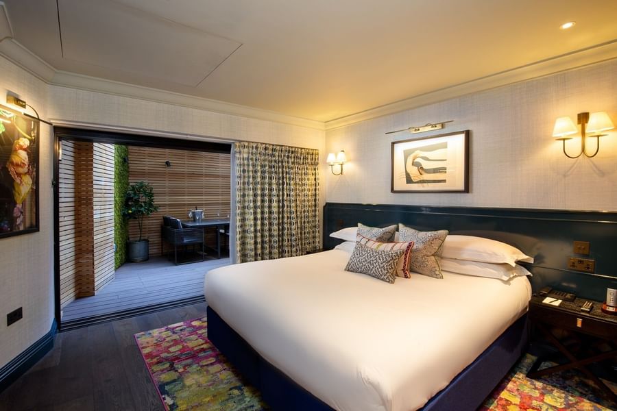 Bed with side tables near glass door in Hyde Park Suite at The Capital Hotel, Apartments and Townhouse