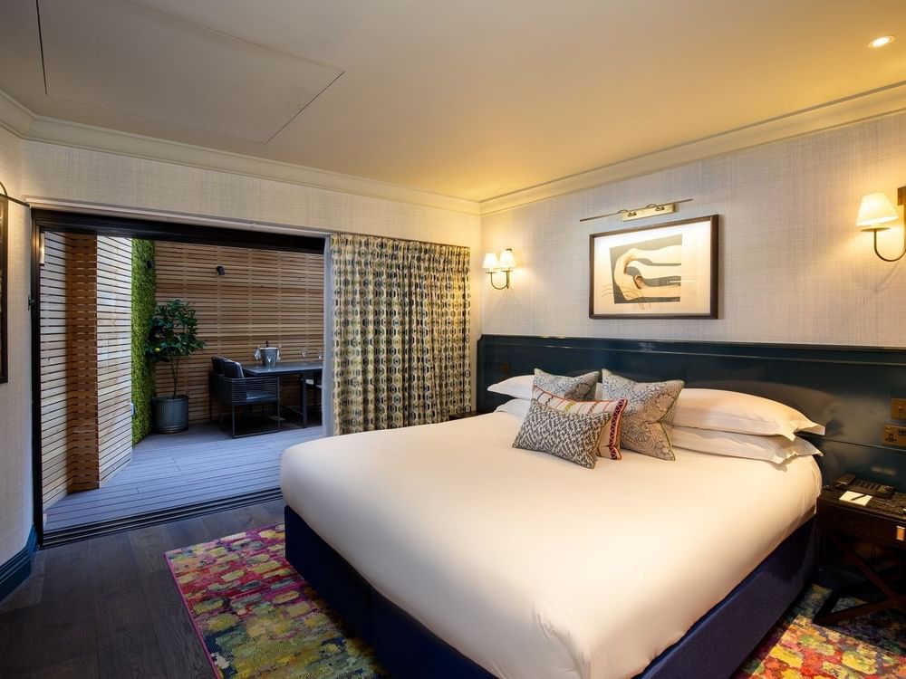 Bed with side tables near glass door in Hyde Park Suite at The Capital Hotel, Apartments and Townhouse