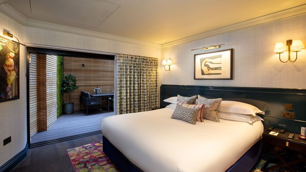 Cozy bedroom with a large bed, vibrant rug, and modern decor.