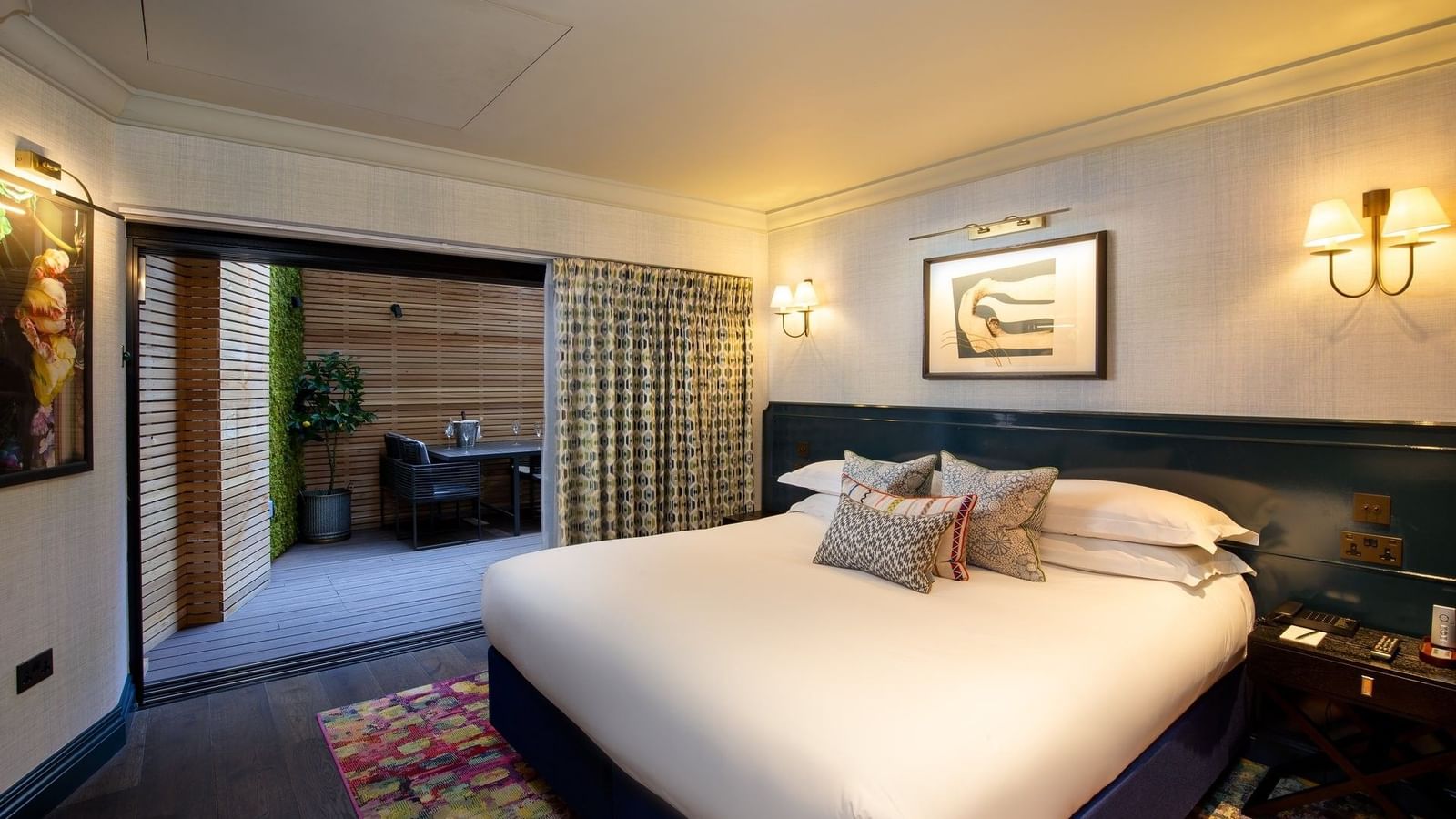 Cozy bedroom with a large bed, vibrant rug, and modern decor.
