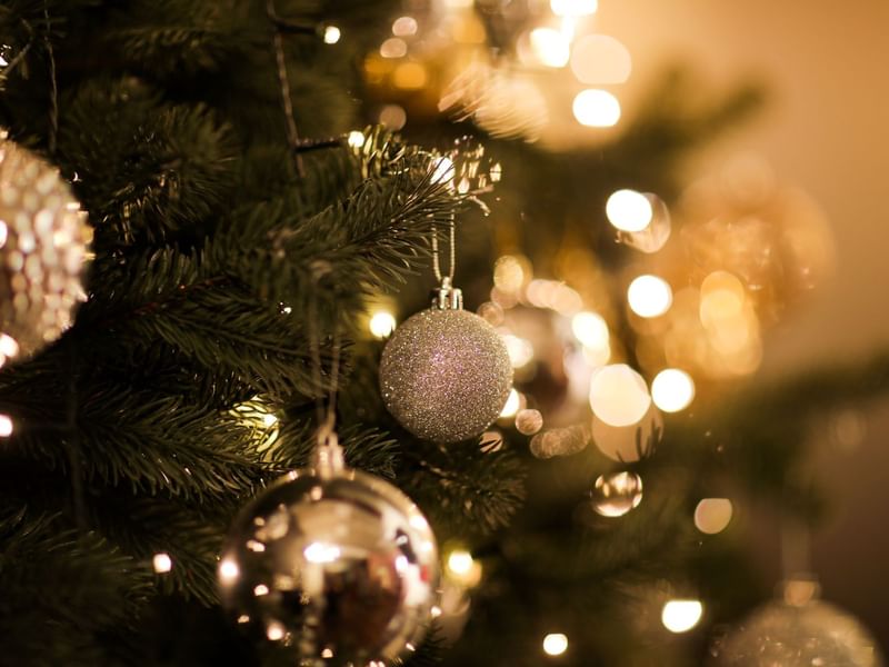 A glowing christmas tree with gold and silver ornaments and lights
