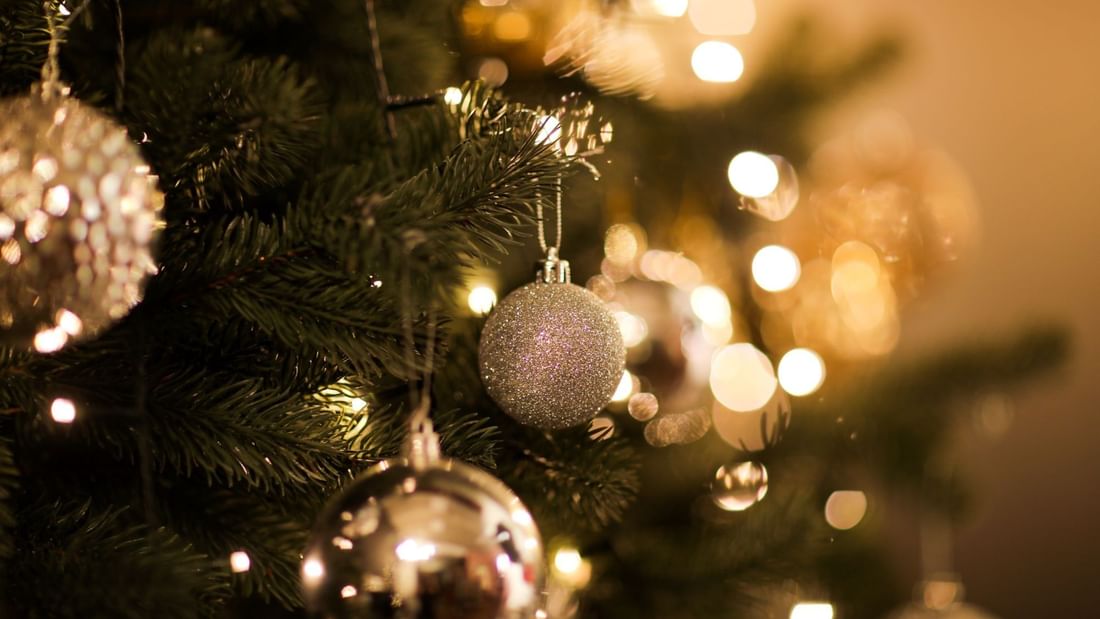 A glowing christmas tree with gold and silver ornaments and lights